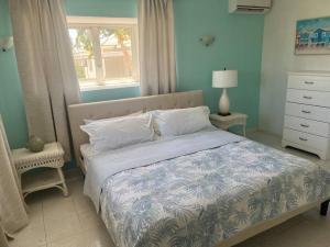 a bedroom with a bed and a window and a dresser at BidaBreezes Villa Great Location in Palm-Eagle Beach