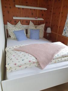 a white bed with blue and white pillows at Ruheidylle Weitblick in Kleinich