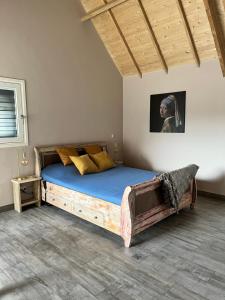 een slaapkamer met een groot houten bed met blauwe lakens bij B & B In Two Hulten in Hulten