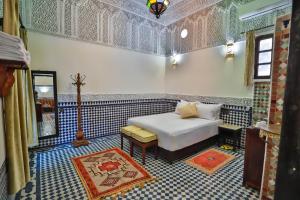 um quarto com uma cama num quarto com azul e branco em Riad Farouzi Fes em Fez