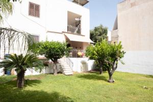 ein weißes Haus mit Bäumen im Hof in der Unterkunft Casa Lisa a due passi dal mare con ampio giardino in San Vito lo Capo