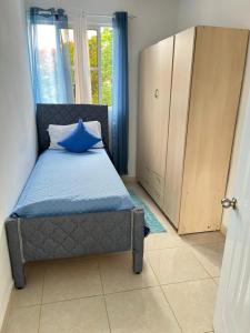 Un dormitorio con una cama con una almohada azul. en Complejo girasol, en Santo Domingo