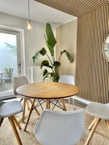 een eetkamer met een tafel en stoelen en een plant bij Großes City-Ferienhaus mit Terrasse, Grill und Parkplatz F19 in Oldenburg