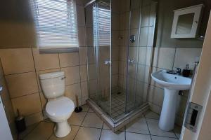 a bathroom with a shower and a toilet and a sink at @LloydsII in Ermelo