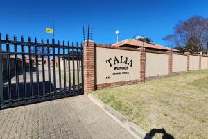 a fence with a sign that reads talia moving company at @LloydsII in Ermelo