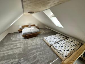 een slaapkamer op zolder met 2 bedden en een dakraam bij Mezonetový apartmán Pernink in Pernink