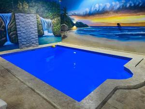 a blue swimming pool in front of a mural at Complejo girasol in Santo Domingo