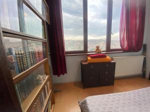 a bedroom with a bed and a view of a city at Welhome to a city centre Cozy and Comfy For leisure and Work No go through No other guests Just one host who you can ghost in Tbilisi City