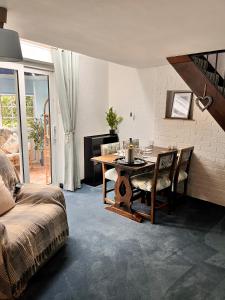 The Snuggery Cottage في تونتون: غرفة معيشة مع طاولة وسرير