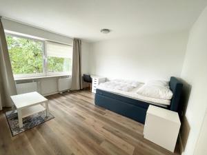a bedroom with a bed and a desk and a window at Zentrale Wohnung mit 3 Schlafzimmer für bis zu 9 Personen in Hamburg