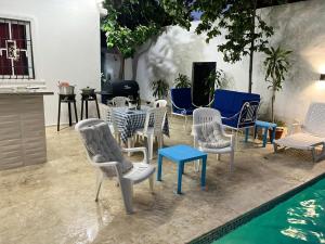 un gruppo di sedie e tavoli accanto a una piscina di Complejo girasol a Santo Domingo