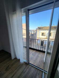 Habitación con puerta corredera de cristal y balcón. en Apartamento La Albariza, en Jerez de la Frontera