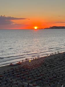 a crowd of people on a beach at sunset at viki sea view apartment in Durrës