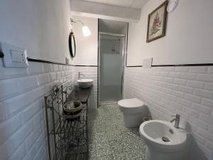 a white bathroom with a toilet and a sink at Villa Maria Cristina in Santa Teresa Gallura