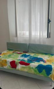un letto con una coperta colorata sopra di Serena e tranquilla casa vacanze in centro a Cirò Marina