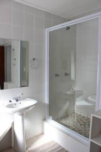 a white bathroom with a sink and a shower at Hysie oppie see in Jongensfontein +20 photos