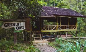 a small cabin with a sign in front of it at Wild Camp in Timbanglawang