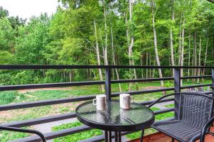 a table and chairs on a balcony with a view of trees at Seaside apartments 2 in Palanga