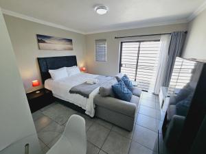 a bedroom with a bed and a couch at Quantum Heights - Studio Apartment in Fourways