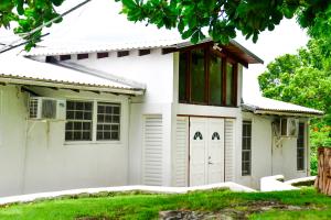 Casa blanca con techo rojo en Morris Apartments, en Saint James