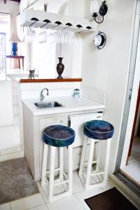 a kitchen with a sink and two blue stools at Morris Apartments in Saint James
