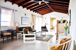 a living room with white furniture and a ceiling at Morris Apartments in Saint James