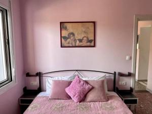 a pink bedroom with a bed with pink pillows at Souda Bay in Souda