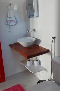 a bathroom with a bowl sink on a wooden counter at CASA TROPICANA - ITAÚNAS Centro in Itaúnas