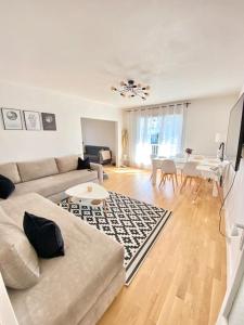 a living room with a couch and a table at Appartement avec deux balcons in Magny-les-Hameaux