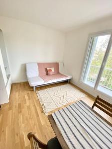 ein Wohnzimmer mit einem weißen Sofa und einem Fenster in der Unterkunft Appartement avec deux balcons in Magny-les-Hameaux