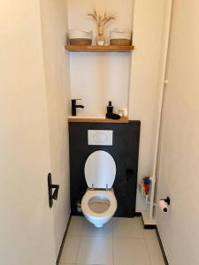 a bathroom with a toilet with a black wall at Appartement avec deux balcons in Magny-les-Hameaux