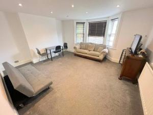 ein Wohnzimmer mit einem Sofa und einem Tisch in der Unterkunft Spacious 1-bedroom Flat in Sutton (South London) in Sutton