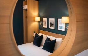 um espelho que reflecte um quarto com uma cama com almofadas pretas e brancas em Celtic Lodge Guesthouse - Restaurant & Bar em Dublin