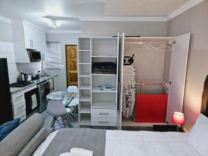 um pequeno quarto com uma cama e uma cozinha com uma cozinha em Quantum Heights - Studio Apartment em Fourways