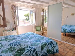 een slaapkamer met een bed en een spiegel bij Mini villa jardin 50 m plage in Borgo
