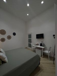 a bedroom with a bed and a desk and a television at La Esperanza De Santa Rita in Bari