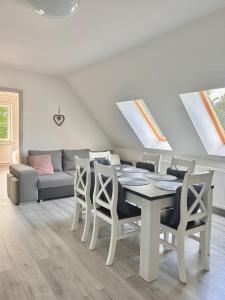 una sala da pranzo con tavolo, sedie e divano di Apartamenty Golf Dyndeby a Neksø