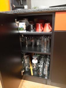 um armário preto com frascos e outros itens nele em къща за гости Градина em Aheloy