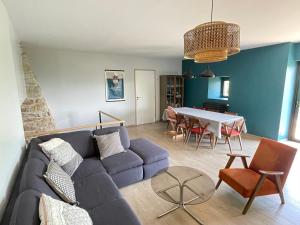 uma sala de estar com um sofá e uma mesa em Gîte La Morille em Ravel