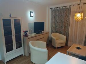 Una sala de estar con un televisor y una mesa y sillas. en Apartamento Victor Arico, en El Médano 4 fotos más