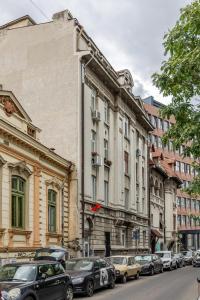 a street with cars parked in front of buildings at Little Attic by CityLife Suites in Bucharest