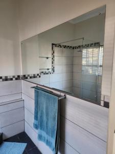 a bathroom with a mirror and a blue towel at Sunny Guest Room in Boksburg