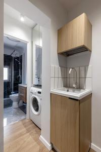 a bathroom with a sink and a washing machine at Little Attic by CityLife Suites in Bucharest