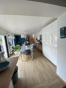 uma cozinha e sala de estar com uma mesa de jantar em Chambre d’hôte près de la plage bis em Pornichet