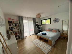 1 dormitorio con cama y espejo. en Chambre d’hôte près de la plage bis en Pornichet