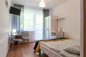 a bedroom with a bed and a desk and a window at Piast in Karwia