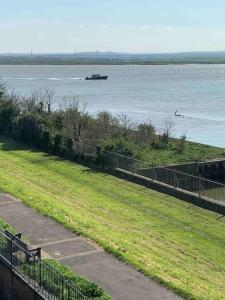 a park with a view of the water and a boat at Two bed flat stylishly furnished in Purfleet