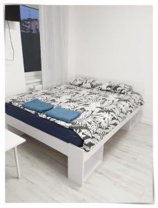 een bed in een witte kamer met een nachtrok bij SouvenirAppart Sienkiewicza in Bydgoszcz