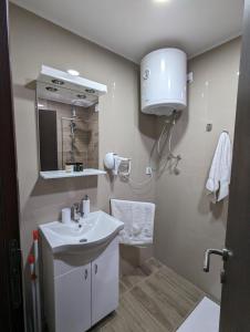 a white bathroom with a sink and a mirror at Silver Jordan in Ostrovo