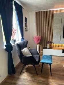 een woonkamer met een stoel en een tafel bij Luxury Apartment near Munich Airport - Therme ED - Parking in Berglern
